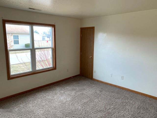 an empty room with a window and a door